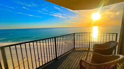a balcony with two chairs looking out at the ocean at Sunbird Resort 11th Floor Free Beach Chairs - by Sunbird Rentals in Panama City Beach