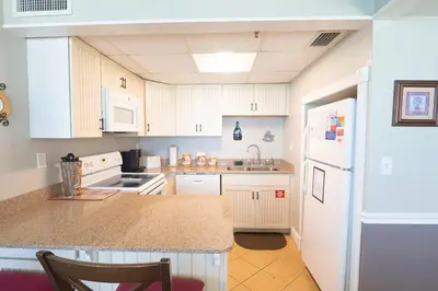 a kitchen with white cabinets and a counter top at Sunbird Resort 11th Floor Free Beach Chairs - by Sunbird Rentals in Panama City Beach