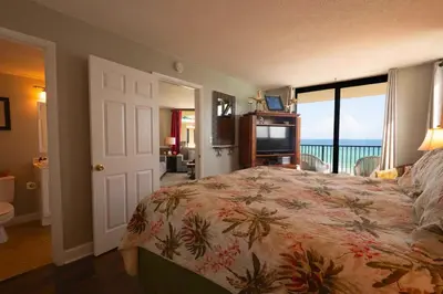 a bedroom with a bed with a view of the ocean at Sunbird Resort 11th Floor Free Beach Chairs - by Sunbird Rentals in Panama City Beach