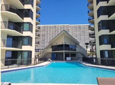a swimming pool in front of two apartment buildings at Sunbird Resort 8th Floor Sunsets - by Sunbird Rentals in Panama City Beach