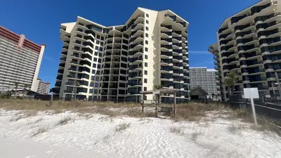 two tall buildings on the beach next to the sand at Sunbird Resort 8th Floor Sunsets - by Sunbird Rentals in Panama City Beach