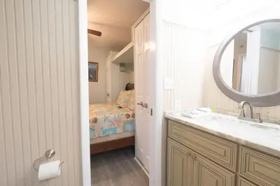 a bathroom with a sink and a bedroom with a bed at Sunbird Resort 8th Floor Stunning Beach View - by Sunbird Rentals in Panama City Beach