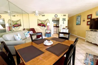 a living room with a wooden table and a couch at Sunbird Resort 5th Floor Amazing View! - by Sunbird Rentals in Panama City Beach
