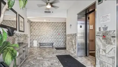 a lobby with a elevator and a stone wall at Gulf-Front Corner Unit! Stunning Coastline Views! by Dolce Vita Getaways PCB in Panama City Beach