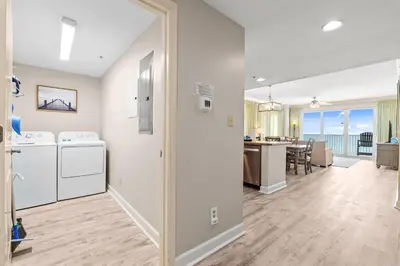 a kitchen and living room with a view of the ocean at Gulf-Front Corner Unit! Stunning Coastline Views! by Dolce Vita Getaways PCB in Panama City Beach