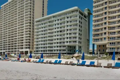 a group of beach chairs and umbrellas on the beach at Gulf-Front Corner Unit! Stunning Coastline Views! by Dolce Vita Getaways PCB in Panama City Beach
