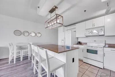 a kitchen with white cabinets and a table and chairs at Laketown Wharf 1116 in Panama City Beach