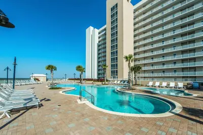 a swimming pool with chairs and a building at Laketown Wharf 1116 in Panama City Beach