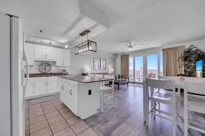 a kitchen and dining room with white cabinets and a table at Laketown Wharf 1116 in Panama City Beach