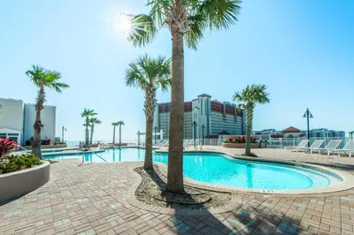 a swimming pool with palm trees in a resort at Laketown Wharf 1116 in Panama City Beach