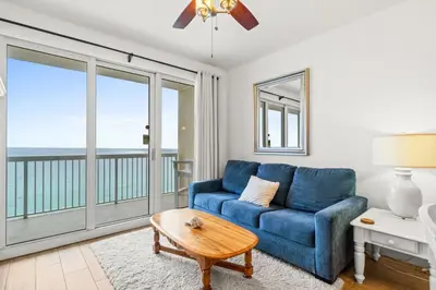 a living room with a blue couch and a view of the ocean at Seychelles Unit 1205 in Panama City Beach