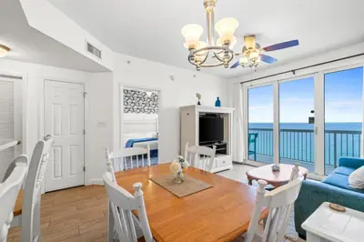 a dining room and living room with a table and chairs at Seychelles Unit 1205 in Panama City Beach