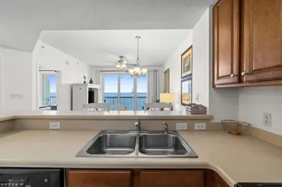 a kitchen with a sink and a view of the ocean at Seychelles Unit 1205 in Panama City Beach