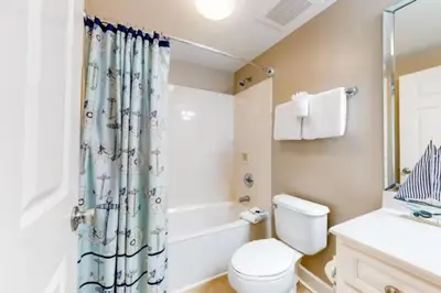 a bathroom with a toilet and a shower curtain at 21st-Floor Sunrise Beach Gulf-Front Condo w/ Bunks & Panoramic Views in Panama City Beach