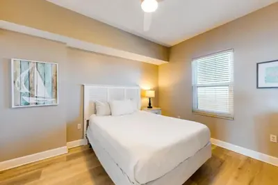a bedroom with a white bed and a window at 21st-Floor Sunrise Beach Gulf-Front Condo w/ Bunks & Panoramic Views in Panama City Beach
