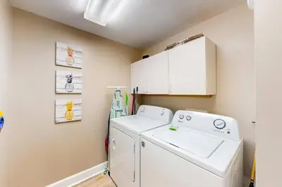 a laundry room with a washing machine and cabinets at 21st-Floor Sunrise Beach Gulf-Front Condo w/ Bunks & Panoramic Views in Panama City Beach