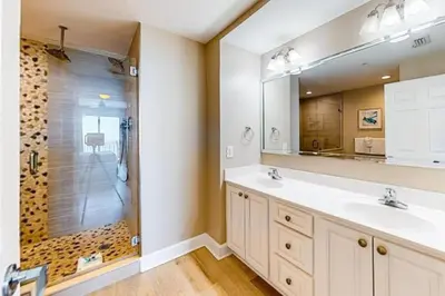 a bathroom with a shower and two sinks and a mirror at 21st-Floor Sunrise Beach Gulf-Front Condo w/ Bunks & Panoramic Views in Panama City Beach