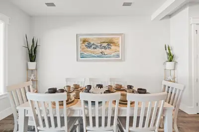 a white dining room with a table and chairs at New 6BR Home Sleeps 20 | Private Pool, Walk to Beach, Near Pier Park in Panama City Beach