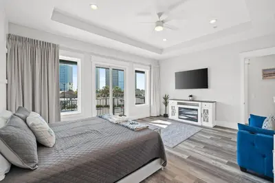 a bedroom with a large bed and a flat screen tv at New 6BR Home Sleeps 20 | Private Pool, Walk to Beach, Near Pier Park in Panama City Beach