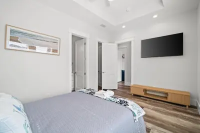 a bedroom with a bed and a flat screen tv at New 6BR Home Sleeps 20 | Private Pool, Walk to Beach, Near Pier Park in Panama City Beach