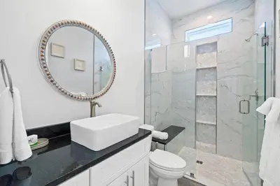 a white bathroom with a sink and a mirror at New 6BR Home Sleeps 20 | Private Pool, Walk to Beach, Near Pier Park in Panama City Beach