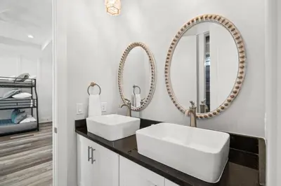 a bathroom with two sinks and two mirrors at New 6BR Home Sleeps 20 | Private Pool, Walk to Beach, Near Pier Park in Panama City Beach