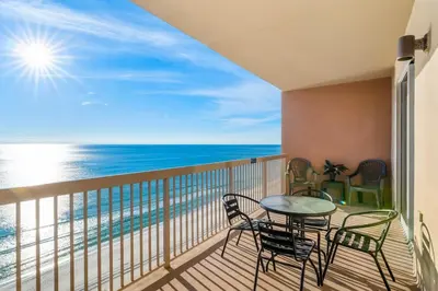 a balcony with a table and chairs and the ocean at Sunrise Beach 14th-Floor Gulf-Front Condo w/ Pools, Bunks & Balcony Views in Panama City Beach