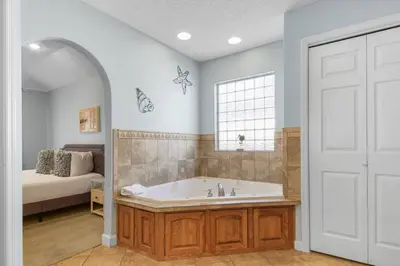 a large bathroom with a tub and a bed at Large Pet-Friendly Beach Home | Sleeps 14 Near Pier Park in Panama City Beach