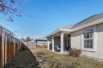 a white house with a fence in front of it at Large Pet-Friendly Beach Home | Sleeps 14 Near Pier Park in Panama City Beach