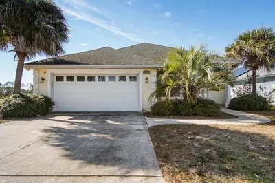 a house with palm trees in front of a driveway at Large Pet-Friendly Beach Home | Sleeps 14 Near Pier Park in Panama City Beach