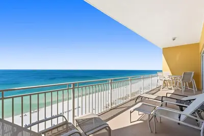 a balcony with chairs and a view of the ocean at Sunrise Beach 14th-Floor Gulf-Front Condo Pools, Bunks & Balcony Views in Panama City Beach