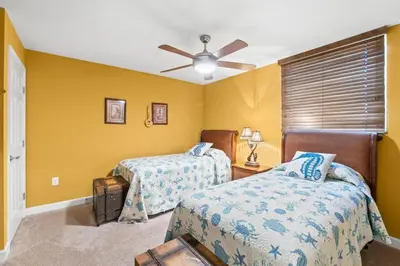 a bedroom with two beds and a ceiling fan at Sunrise Beach 14th-Floor Gulf-Front Condo Pools, Bunks & Balcony Views in Panama City Beach
