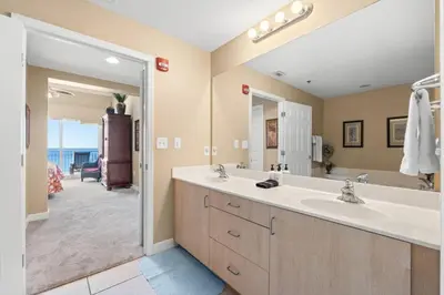 a bathroom with two sinks and a large mirror at Sunrise Beach 14th-Floor Gulf-Front Condo Pools, Bunks & Balcony Views in Panama City Beach