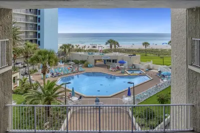 a view of the pool and beach from the balcony of a resort at Top of the Gulf 620 Beachfront Couples Retreat in Panama City Beach