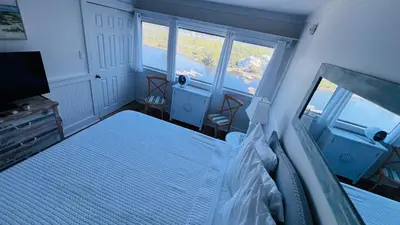 a bedroom with a bed and a tv and windows at Stunning condo in Pinnacle Port, Panama City Beach in Panama City Beach