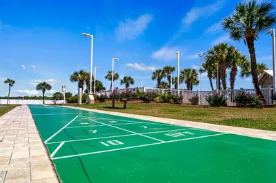 a tennis court in a park with palm trees at Stunning condo in Pinnacle Port, Panama City Beach in Panama City Beach