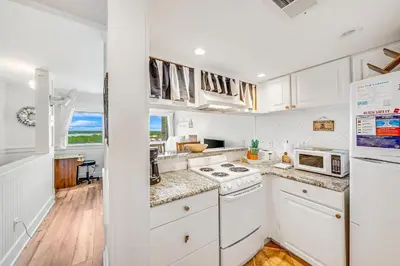 a kitchen with white cabinets and a stove top oven at Stunning condo in Pinnacle Port, Panama City Beach in Panama City Beach