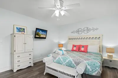 a bedroom with a bed and a chair and a ceiling fan at SeaRenity Awaits: 2-BD, 2-BA Coastal Escape! Perfect for 5! Pet Friendly! in Laguna Beach
