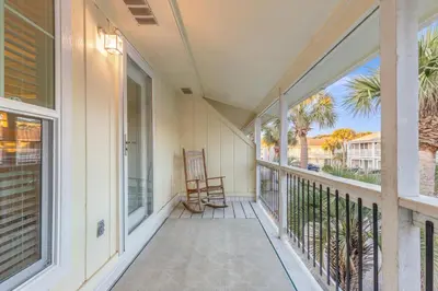 a porch with a rocking chair and a view of the ocean at SeaRenity Awaits: 2-BD, 2-BA Coastal Escape! Perfect for 5! Pet Friendly! in Laguna Beach