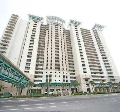 a large white apartment building with a street in front at Aqua Beach Resort by Panhandle Getaways in Panama City Beach