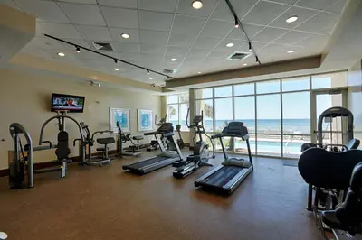 a gym with treadmills and cardio equipment in a building at Aqua Beach Resort by Panhandle Getaways in Panama City Beach