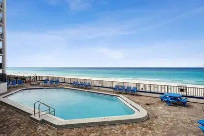 a swimming pool with the beach in the background at AquaVista Beach Resort by Panhandle Getaways in Panama City Beach