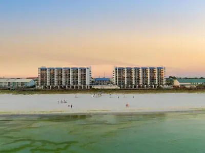 a group of people on a beach with buildings at AquaVista Beach Resort by Panhandle Getaways in Panama City Beach