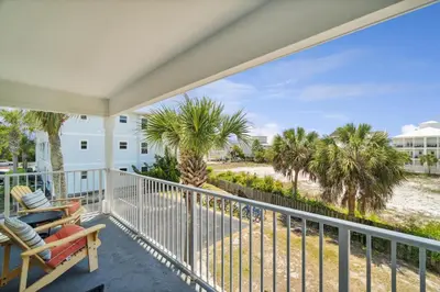 a balcony with a view of the beach and palm trees at Beachside Villas by Panhandle Getaways in Seagrove Beach