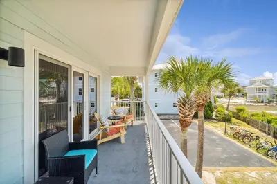 a porch with chairs and palm trees on a house at Beachside Villas by Panhandle Getaways in Seagrove Beach