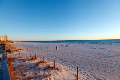 a group of people walking on the beach at Boardwalk Beach Resort by Panhandle Getaways in Panama City Beach
