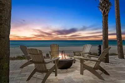 three chairs and a fire pit on the beach at Calypso Resort by Panhandle Getaways in Panama City Beach