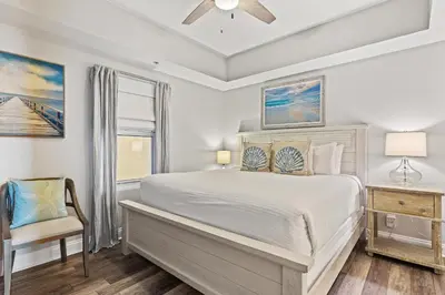 a bedroom with a bed and a chair and a window at Calypso Resort by Panhandle Getaways in Panama City Beach