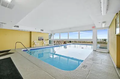 a large swimming pool in a building with a large window at Emerald Isle by Panhandle Getaways in Panama City Beach