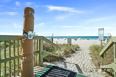 a pole on the beach with the ocean in the background at Emerald Isle by Panhandle Getaways in Panama City Beach